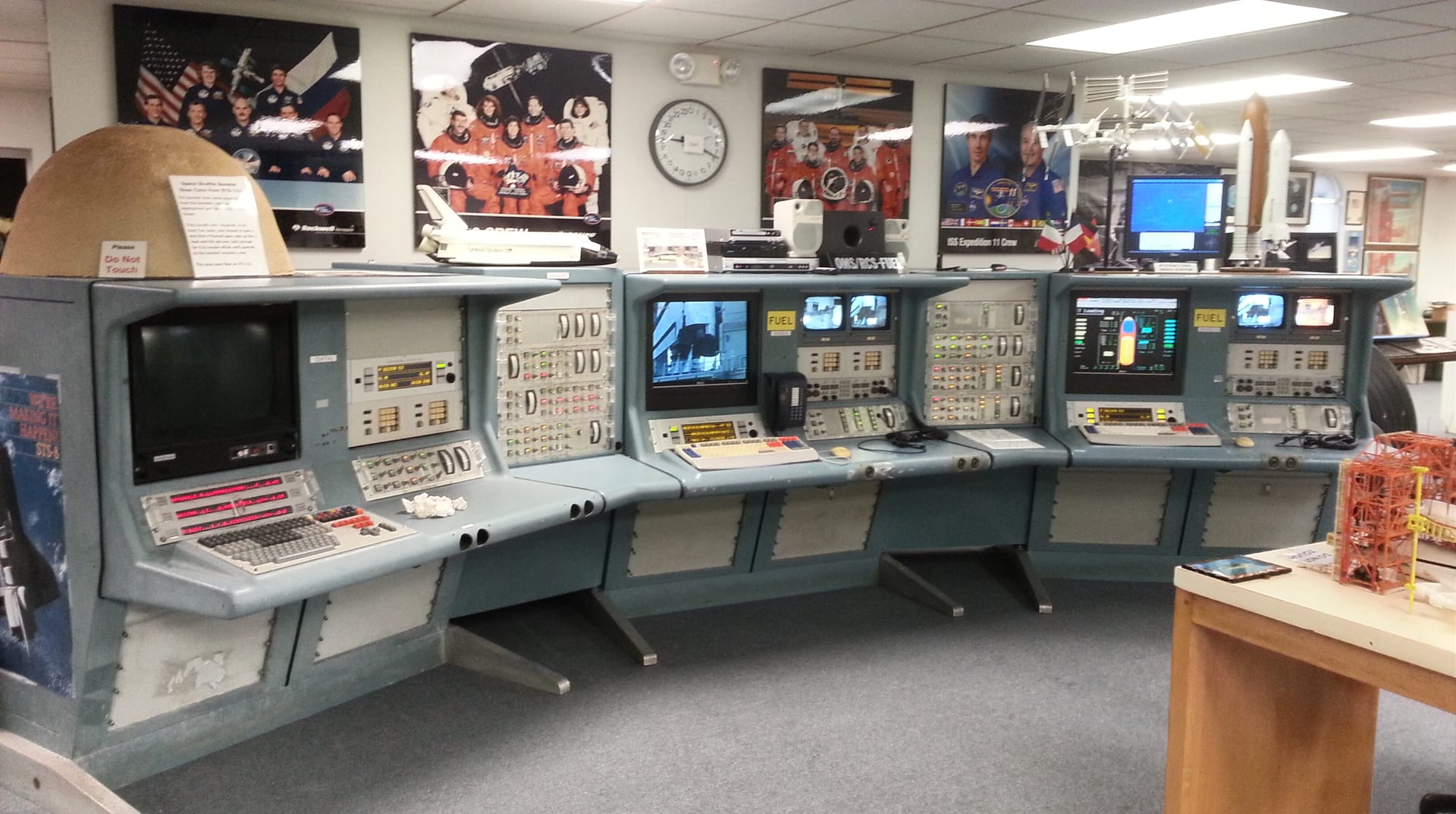 Rows of working launch consoles mounted along a museum gallery wall.