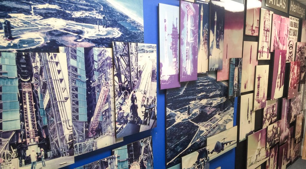 A museum wall displays historical photographs of launch vehicles and facilities.